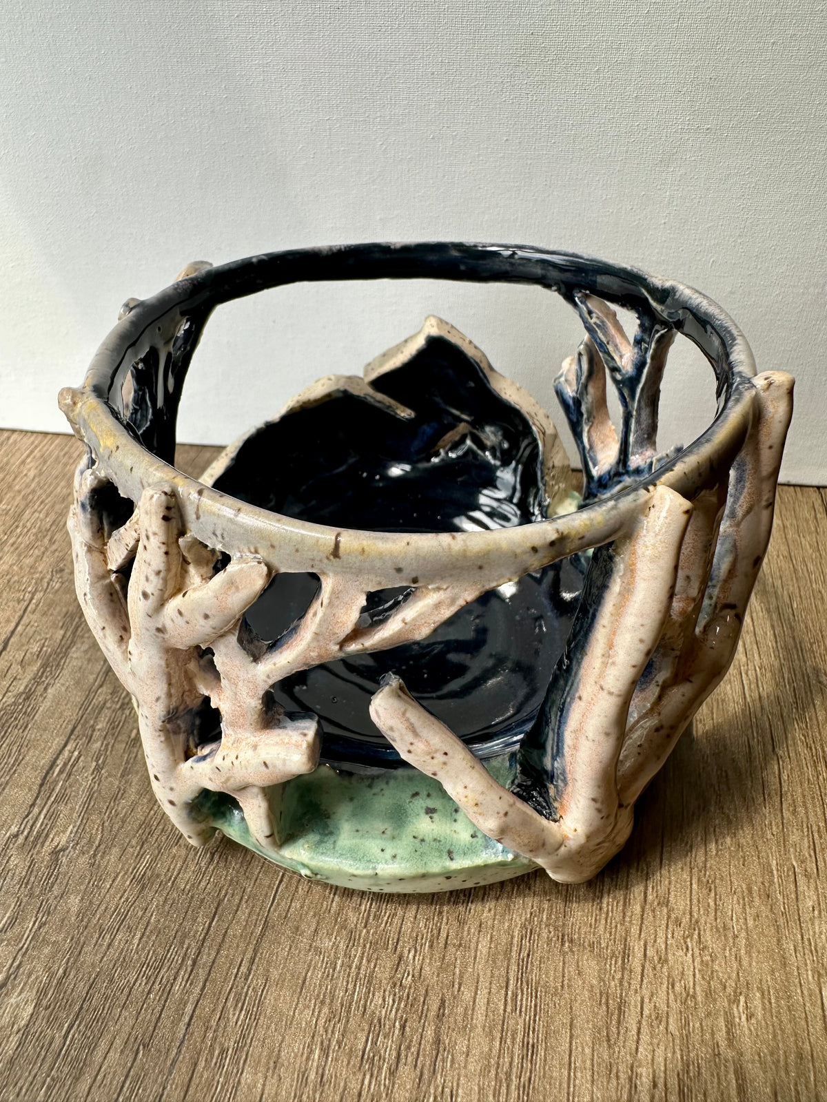Round ceramic candle surround with mountain and birch trees cut out.